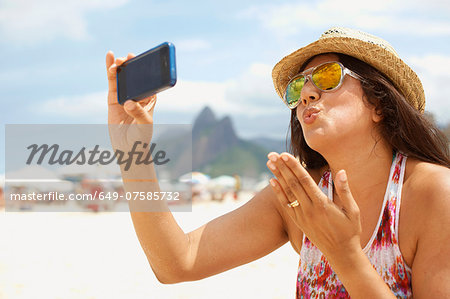 Mature woman taking a self portrait, Ipanema beach, Rio De Janeiro, Brazil