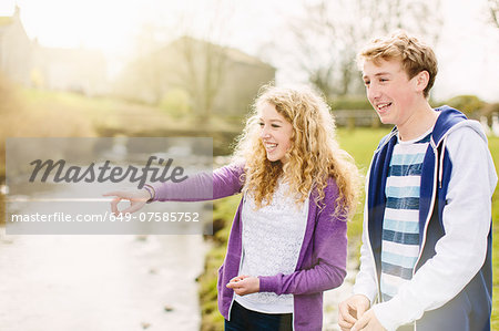 Teenage brother and sister on rural riverbank