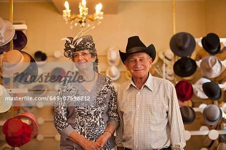 Portrait of senior couple in traditional milliners shop