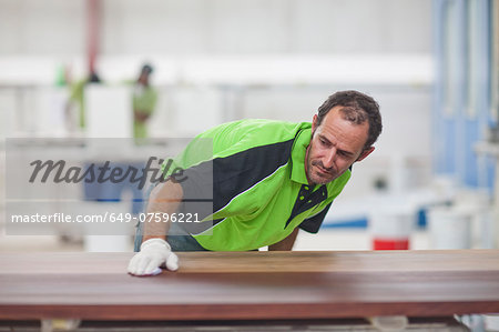 Carpenter checking quality of wood in workshop Carpenter checking quality of wood in workshop