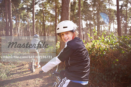 Twin brothers on BMX bikes in forest
