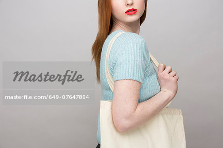 Cropped image of young woman carrying shopping bag