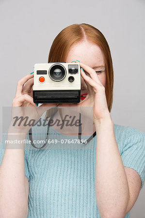 Young woman with polaroid camera