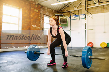 Woman lifting barbell in gym