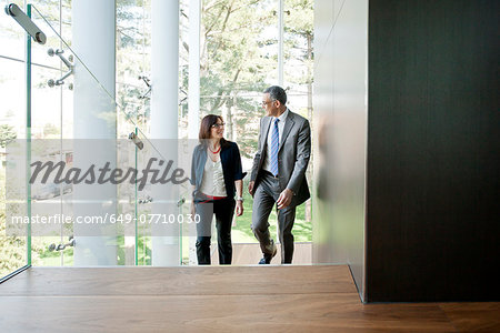 Businessman and woman walking up stairs