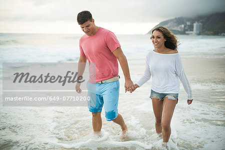 Young couple paddling in ocean, Ipanema Beach, Rio de Janeiro, Brazil