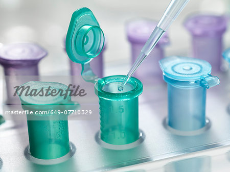 Pipette dropping a solution into a vial, used for storing liquid during chemical or biological research