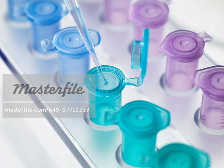 Pipette dropping a solution into a vial, used for storing liquid during chemical or biological research
