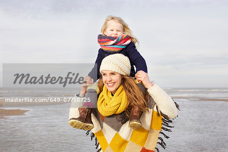 Mid adult woman shoulder carrying daughter on beach, Bloemendaal aan Zee, Netherlands