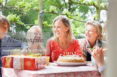 Girl making birthday wish with her family at birthday party