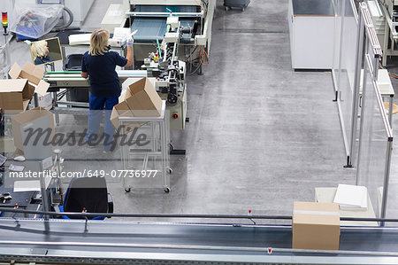 Mature woman working in paper packaging factory
