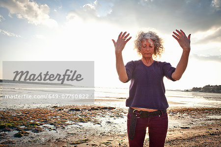 Mature woman exercising on beach