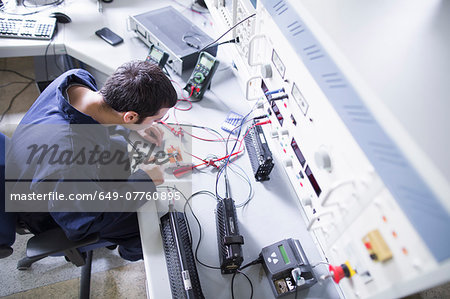 High angle view of male electrician repairing electronic equipment in workshop High angle view of male electrician repairing electronic equipment in workshop