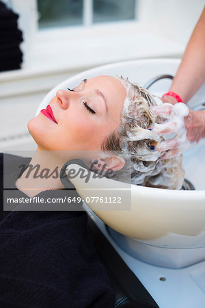 Woman having hair shampooed in salon