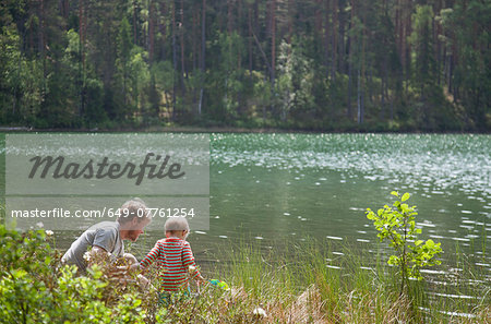 Father and son looking down into lake, Somerniemi, Finland