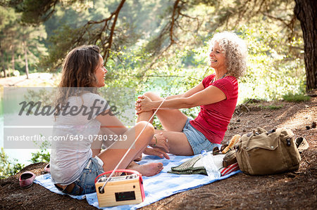 Mother and daughter on picnic blanket by the Blue Pool, Wareham, Dorset, United Kingdom