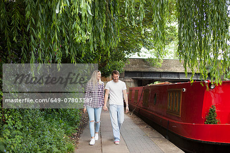 Couple walking along canal, East London, UK