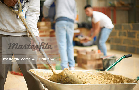 Cropped shot of three male college students in bricklaying workshop