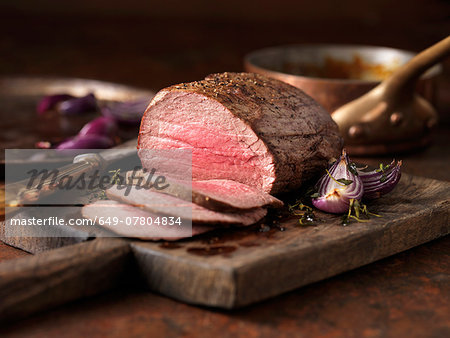 Christmas dinner. Chateaubriand steak cooked with a thick cut from the tenderloin filet, rare medium served with roasted onions, pepper and herbs