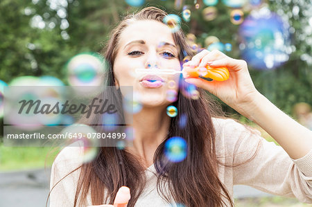 Young woman blowing bubbles