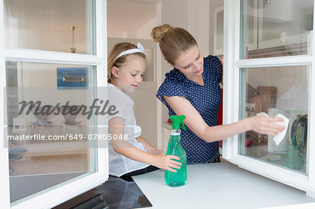Mother and daughter cleaning window