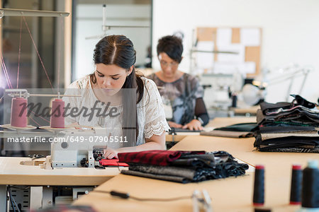 Two seamstresses using sewing machines in workshop