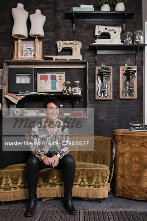 Portrait of mature seamstress sitting in quirky reception at workshop