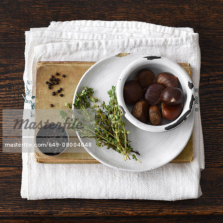 Chestnuts, plate, thyme, book, black pepper, kitchen towel