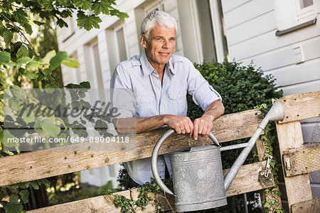 Mature man with watering can in garden