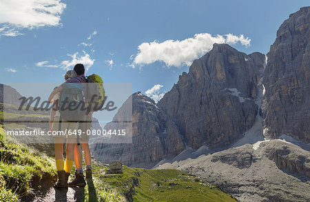 Rear view of hiking couple looking over valley, Brentei Hut, Brenta Dolomite, Italy