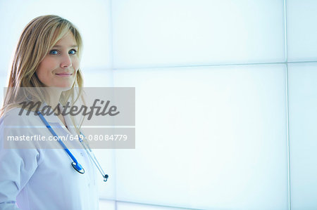 Doctor posing against backlit wall panel