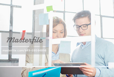 Businessman and woman looking at digital tablet