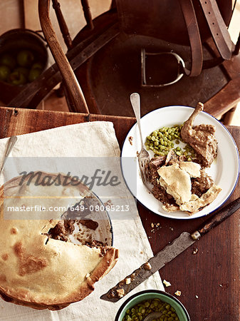 Rustic table with meal of raised pigeon pie