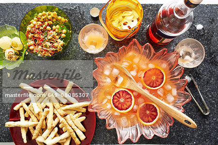 Still life of punch cocktail bowl with crisps and snacks