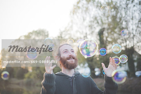 Young man playing with bubbles