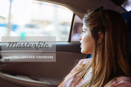 Young woman looking out of taxi window, Manila, Philippines