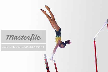 Young gymnast performing on uneven bars