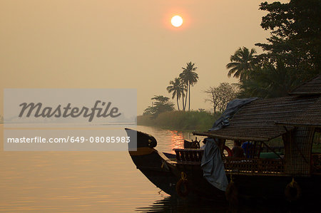 Boat on water at sunrise, Kerala, India