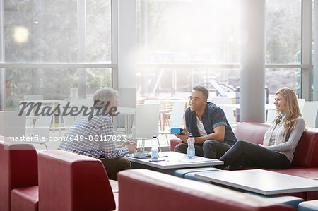 Businessmen and woman meeting on office sofas Businessmen and woman meeting on office sofas