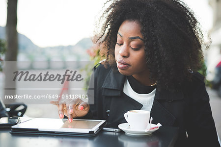 Young woman using digital tablet at sidewalk cafe, Lake Como, Como, Italy Young woman using digital tablet at sidewalk cafe, Lake Como, Como, Italy