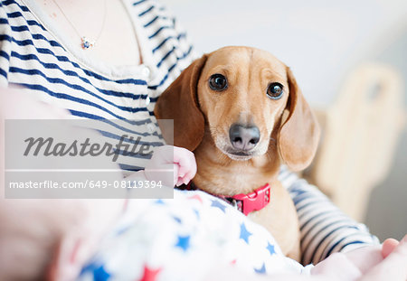 Woman holding baby and dog