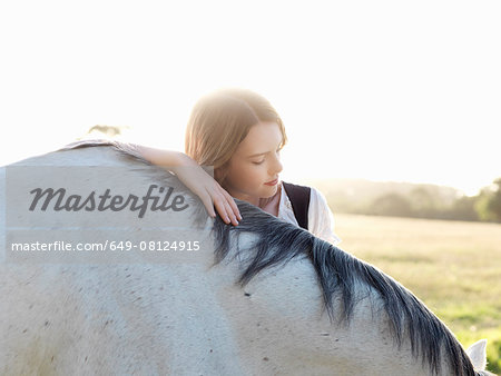 Portrait of teenage girl with grey horse
