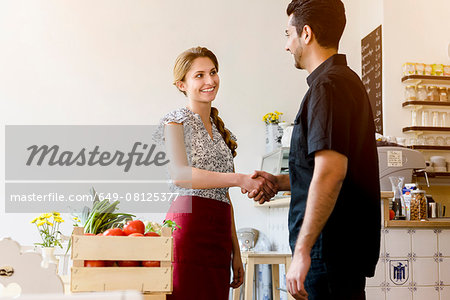 Young woman shaking mans hand