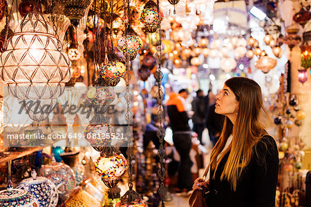 Young woman looking at lights on market stall, Istanbul, Turkey