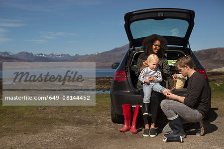 Parents helping son change shoes, Loch Eishort, Isle of Skye, Hebrides, Scotland