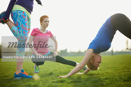 Three women exercising and stretching in the park