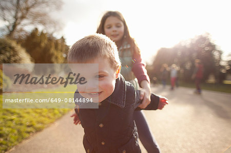 Boy and sister playing in park