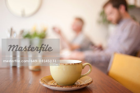 Cup on table and people in background in a cafe