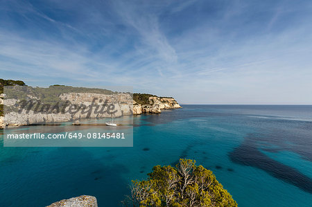 View of Cala Macarella and sailboat, Menorca, Spain