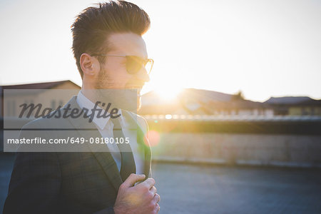 Stylish young man wearing shades in sunlight